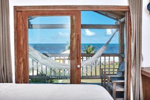 1 dormitorio con cama y vistas al océano en Tamikuã Mar Pousada, en Caraíva
