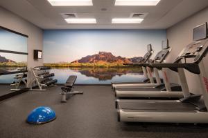 einen Fitnessraum mit Stühlen und ein großes Gemälde an der Wand in der Unterkunft Courtyard by Marriott Scottsdale Salt River in Scottsdale