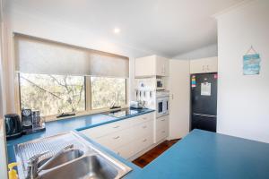 a kitchen with a blue counter top and a refrigerator at The Blue House - 100M TO BEACH, PET FRIENDLY, BIG HOUSE, SLEEPS 8 in Point Lookout