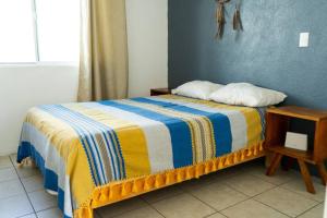 a bedroom with a bed with a yellow and blue blanket at Tu refugio en Tequesquitengo Casa once88 in Tlatenchu