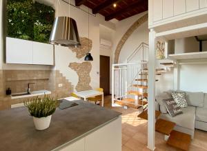 eine Küche und ein Wohnzimmer mit einem Waschbecken und einem Sofa in der Unterkunft Il Barchio loft in un palazzo di fine 800 a Jesi in Iesi