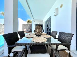comedor con mesa y sillas en Villas Mamma Mia pool heat Private & Jacuzzi, en Playa Blanca