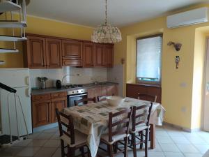 a kitchen with a table and chairs and a kitchen with yellow walls at Bilocale La Tezia in Marciana Marina +15 photos
