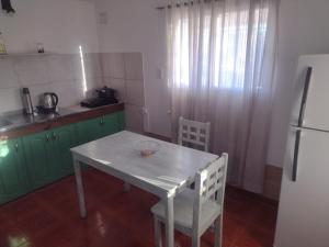 a kitchen with a white table and a refrigerator at Flor de Cardón in La Rioja
