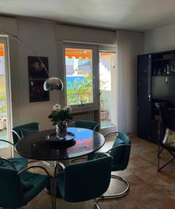 a dining room with a table and green chairs at TERRAZZA vista MARE - SEA view Terrace in Sanremo