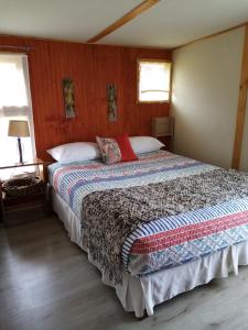 1 dormitorio con 1 cama grande en una habitación en Cabañas Rincón de Ten Ten, en Castro