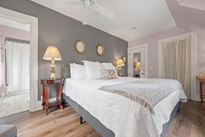 um quarto com uma grande cama branca e 2 espelhos em Brook Farm Inn em Lenox