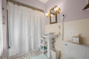 a bathroom with a white shower curtain and a sink at Brook Farm Inn in Lenox