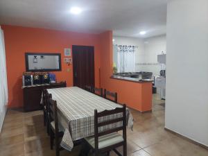 a dining room with a table and a kitchen at Casa Aconchego - piscina com hidromassagem in Guaratuba