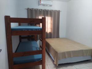 um pequeno quarto com um beliche e um beliche gmaxwell gmaxwell gmaxwell em Casa Aconchego - piscina com hidromassagem em Guaratuba