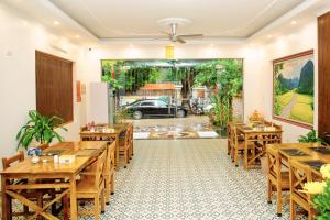 un restaurante con mesas de madera y un coche al aire libre en Tam Coc Center Boutique Hotel, en Ninh Binh