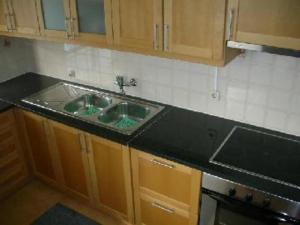 - une cuisine avec un plan de travail noir et un évier dans l'établissement Apartamento Areias Mar, à Albufeira