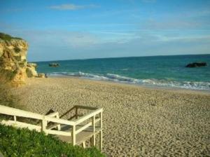 une clôture blanche sur une plage de sable près de l'océan dans l'établissement Apartamento Areias Mar, à Albufeira