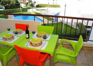 d'une table et de chaises vertes sur un balcon dans l'établissement Apartamento Areias Mar, à Albufeira