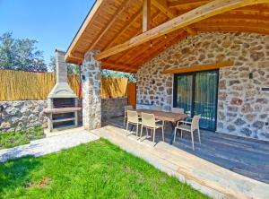 d'une terrasse avec une table, des chaises et une cheminée. dans l'établissement Villa Harmony, à Fethiye