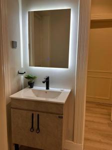 ein Bad mit einem Waschbecken und einem Spiegel in der Unterkunft شقة دخول ذاتي Modern Apartment North Ring110 in Riad