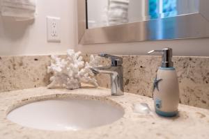 a bathroom sink with a soap dispenser on it at Unit 4 Maui Ohana Modern Studio in Wailuku