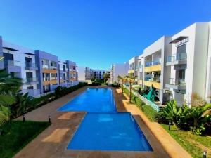 an apartment complex with a swimming pool in front of buildings at Sunny Apartment with Pool View & Terrace in Casablanca