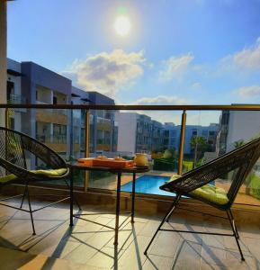 balkon ze stołem, 2 krzesłami i basenem w obiekcie Ocean Palm Aρραrt Pοοl Vieω w mieście Casablanca