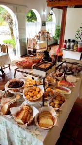 a table filled with different types of bread and pastries at Pousada Della Vegas in Serra Negra