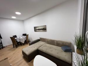 a living room with a couch and a table at ApartmentsByMatyrafa-I in Tarnowskie Góry