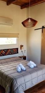 1 dormitorio con 1 cama grande y 2 toallas. en Malvón en Cafayate