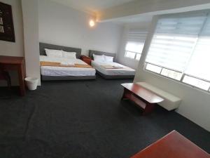 2 Betten in einem Zimmer mit 2 Fenstern in der Unterkunft Mi Hotel 2 Dungun in Dungun
