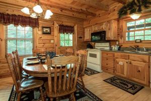 a kitchen with a table and chairs in a cabin at Return To Me, 3 Bedrooms, Sleeps 9, Pool Table, Hot Tub, Gas Fireplace in Sevierville