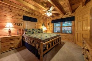 a bedroom with a bed in a log cabin at Return To Me, 3 Bedrooms, Sleeps 9, Pool Table, Hot Tub, Gas Fireplace in Sevierville