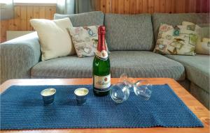 uma garrafa de vinho sentada numa mesa numa sala de estar em Nice Home In Letafors With Kitchen em Letafors