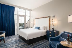 a hotel room with a bed and a blue couch at JW Marriott Savannah Plant Riverside District in Savannah