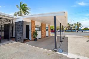 an empty building with a palm tree in a street at Bel Air Motel in Mackay