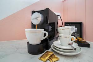 two coffee cups on a counter next to a coffee maker at Bel Air Motel in Mackay