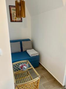 - un salon avec un canapé bleu et un panier dans l'établissement Apartman Anastasija Jezero, à Divčibare