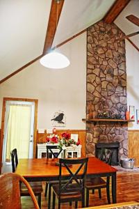 a dining room with a table and a stone fireplace at Our Private Wooded Cabin in Chatham