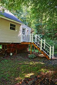 a house with a staircase leading to a deck at Our Private Wooded Cabin in Chatham