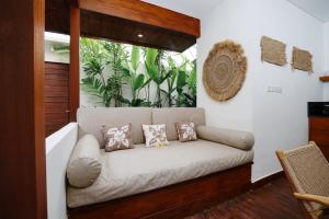 un divano in una stanza con finestra di Villa Pulau I, 1BR Luxury Private Villa with Pool in North of Bali, Pemuteran, within Walking Distance to a Wild Beach a Buleleng
