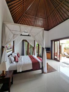 Un dormitorio con una cama grande con dosel. en Uma Padi Villa, en Ubud 93 fotos más