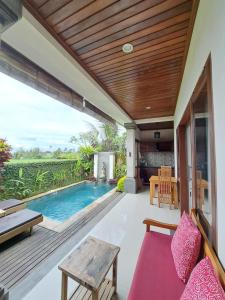 an outdoor patio with a pool and a wooden ceiling at Uma Padi Villa in Ubud
