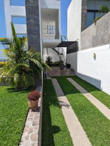 a house with a grassy yard next to a building at Casa entera en exclusiva privada in Tequesquitengo