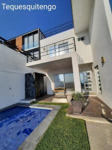 a house with a swimming pool in the yard at Casa entera en exclusiva privada in Tequesquitengo