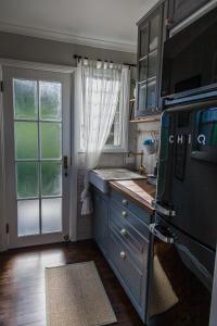 una cocina con armarios azules y una ventana en Wollombi Wines, en Wollombi
