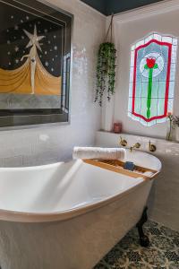 瓦倫比的住宿－Wollombi Wines，带浴缸的浴室,浴室设有彩色玻璃窗