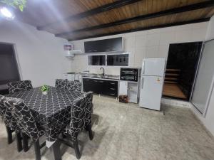 cocina con mesa, sillas y nevera en Departamento FREGO en El Volcán