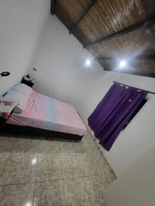 1 dormitorio con cama y ventana púrpura en Departamento FREGO en El Volcán