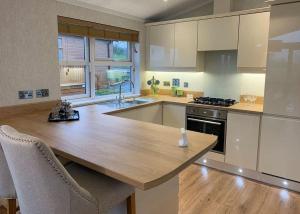 uma cozinha com uma mesa de madeira e uma bancada em Badgers Retreat Holiday Park em Hunton