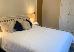 uma cama branca com almofadas num quarto em Badgers Retreat Holiday Park em Hunton