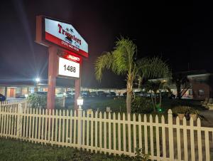 um sinal para um restaurante krispy kreme atrás de uma cerca em Travelers Inn - Clearwater em Clearwater