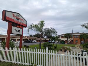 una señal para un restaurante junto a una valla blanca en Travelers Inn - Clearwater, en Clearwater