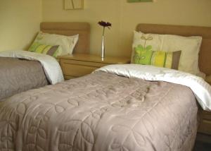Un dormitorio con 2 camas y una mesa con un jarrón. en Weir Holiday Park, en Holtby